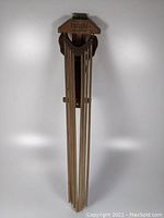 Full front view of the wooden clothes dryer in folded position against white background.