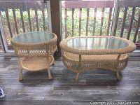 Pair of wicker tables, round and rectangular, shown side by side near window with natural light.