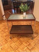Photo of full vintage Hotray rolling warming hostess cart with small ceramic vase holding faux greenery on the top glass shelf
