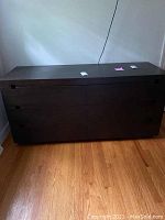 Front view of six drawer dark wood dresser with some visible marks on the top surface and drawers.