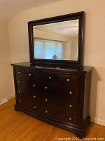Full view of dark wood nine drawer dresser with attached mirror above it, showing overall condition and style.