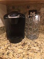 Keurig coffee maker placed on granite kitchen counter next to metal pod holder