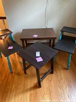 Set of four side tables, three visible, including pair of matching tables and single square table