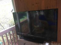 Front view of the Insignia television showing the screen and black glossy frame on a pedestal stand.