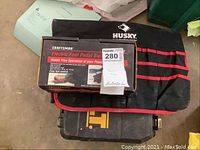 Craftsman electric foot pedal switch in original box placed on top of Husky tool pouch and Dewalt case