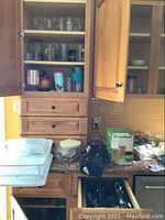 Kitchen counter with FoodSaver system box and open shelving with glassware and kitchen items