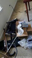 Wide angle photo showing black walking boot with adjustable straps, some CPAP supplies, stethoscope, and black lumbar brace.