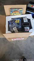 Photo of a box containing the framed Jimmie Johnson NASCAR collectible and the NASCAR cookbook.