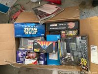 Overhead view of open box showing various boxed NASCAR model cars and collectibles including a clear boxed figurine.