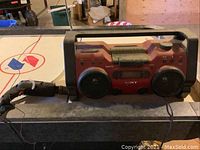 Sony 25 h1OCP personal audio system red color with black dual speakers, cassette player in the center, control knobs and buttons visible, dusty condition.