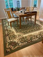 View of the full rug under a dining table showing the pattern and size.