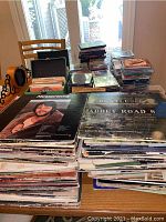 Overview of stacks of vinyl, CDs, and DVDs on table