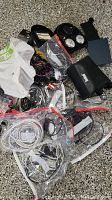 Photo showing assorted cables, cords, and plugs, along with Bose headphones and other items on floor.