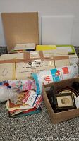 Wide shot of the lot showing packaged quilting frame, poly-fil batting, stacked folders, and various booklets.