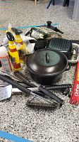 Overview of grilling supplies including cast iron pot, spray bottles, wood chips, and foil pans