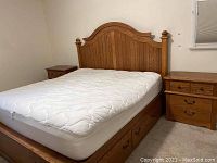 Photo of a wooden bed flanked by two matching wooden nightstands with drawers