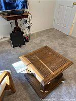 Top-angle view of the smaller square wooden side table showing veneer loss and wood grain pattern.