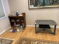 TV stand and wood bookcase in room showing layout and condition