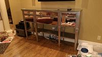 Full front view of console cabinet showing six mirrored drawers, open shelf, and glass top.
