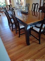 Dining table with 6 matching chairs from side showing table top and chair backs