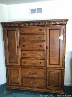 Full front view of the men's chest cabinet showing 7 drawers and 4 cabinets with carved top detailing.