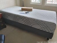 Assembled adjustable bed frame with mattress in bedroom under window