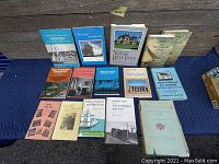 Photo showing thirteen antique and vintage books about Newport, Rhode Island, and New England arranged on a blue cloth with wooden background.