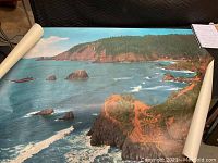 Full view of the signed ocean landscape art piece showing coastline and waves.