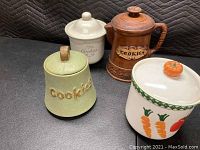 Four different vintage cookie jars displayed on black background