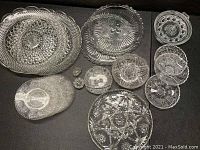 Top-down view showing a set of cut crystal platters and bowls with intricate starburst and geometric patterns.