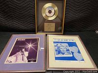 Overall view of gold record plaque and two framed photographs