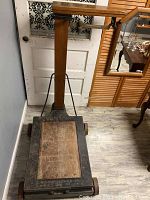 Full view of the large antique scale featuring wooden platform and metal framing, showing overall condition and size.