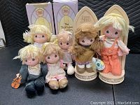 Photo of six Precious Moments dolls, some with original boxes behind them.