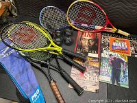 All items together showing racquetball and tennis rackets with magazines and eyewear on black surface.