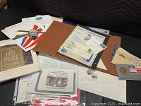 View of various collectors and commemorative postage stamps and envelopes in folders and loose sheets.