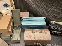 Three different toolboxes visible: a light blue Kennedy toolbox, a rusted toolbox, and a long blue toolbox alongside four small metal boxes.