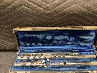 Photo of the vintage Bundy Selmer flute in its open hard case with blue velvet lining, showing the flute in multiple sections.