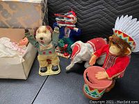 Wide view of the lot showing Cragstan dog toy, monkey doll, elephant toy, sailor doll with accordion, and other vintage toys.
