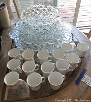 Full view of punch bowl, serving tray, and Corning Ware mugs arranged on glass table