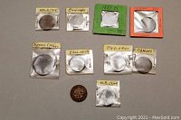 Ten antique copper pennies from Canadian regions and years 1857-1919 in cardboard holders with labels indicating year and origin.