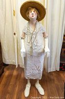 Front view of life-size female paper-mache statue in white dress