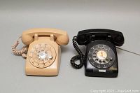 Both beige and black Northern Telecom rotary telephones front view