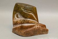 Front angled view of the large polished stone carving showing the abstract indigenous design.