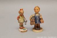 Photo of the pair of Goebel figurines from front angle, showing details and colors, with girl watering a flower and boy holding shoes.