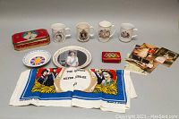 Full overview of lot including plates, mugs, tins, handkerchief and photos.