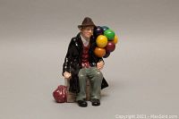 Front view of Royal Doulton Balloon Man figurine showing seated man holding colorful balloons with detail on face, clothing, and accessories.