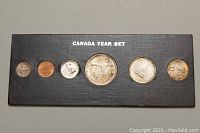Top view of six coins mounted in black holder labeled CANADA YEAR SET, showing tarnished silver coins and brown copper penny.
