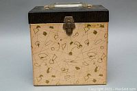 Front view of vintage vinyl record storage box with black top and cream patterned base