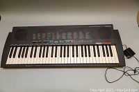 Full view of Yamaha PSR-18 keyboard showing 49 keys, control panel and speaker grille.