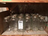 Two photos of multiple large glass Mason jars with metal lids arranged on basement shelving.